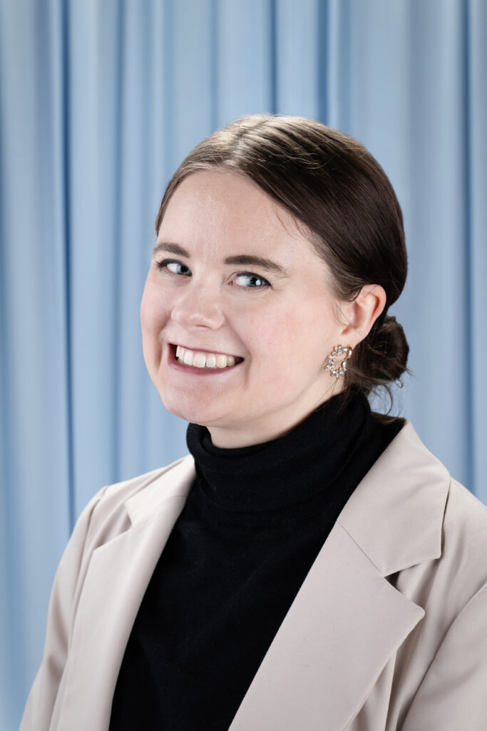 Sydney Budgeon, a white woman with a short ponytail in a turtleneck and blazer