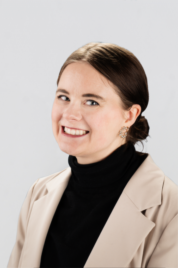 Sydney Budgeon, a white woman with a short ponytail in a turtleneck and blazer